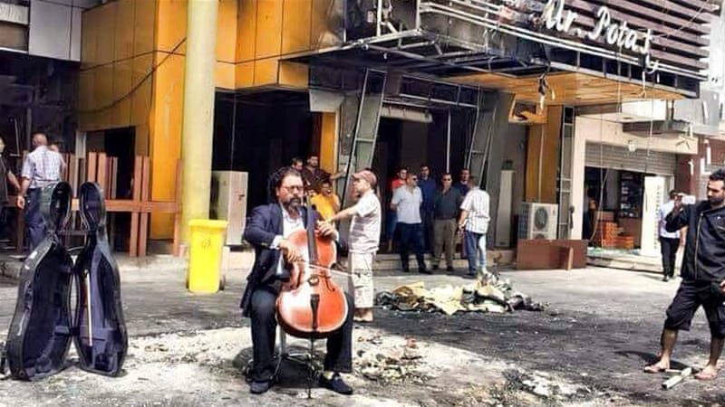 Karim Wasfi plays cello at bomb site in Baghdad