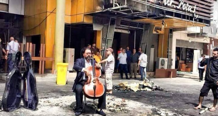 Karim Wasfi plays cello at bomb site in Baghdad