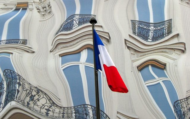Distorted buildings behind a French flag